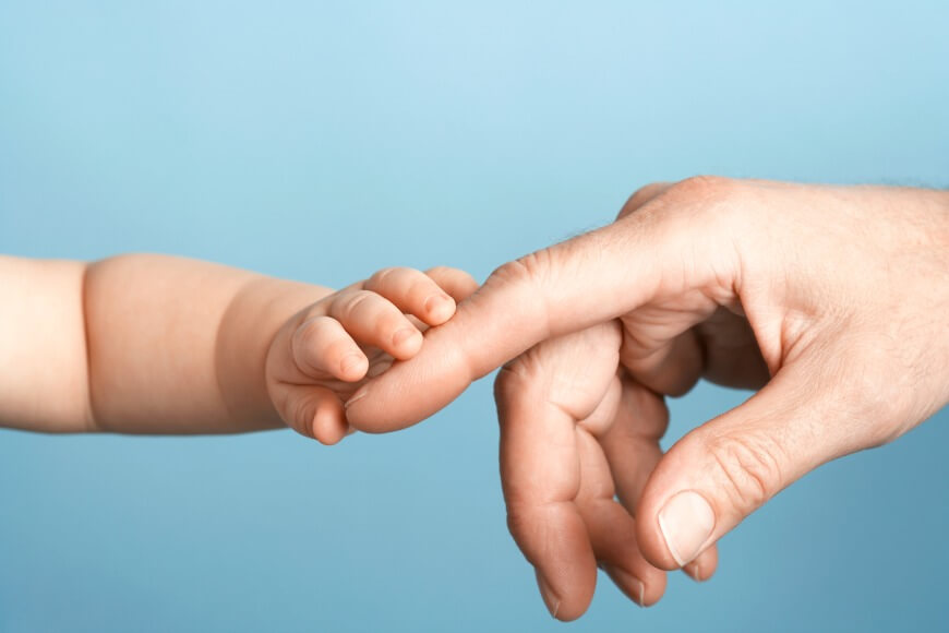 יד של תינוק נוגעת באצבע של מבוגר
