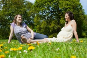 pregnant women sitting on the grass